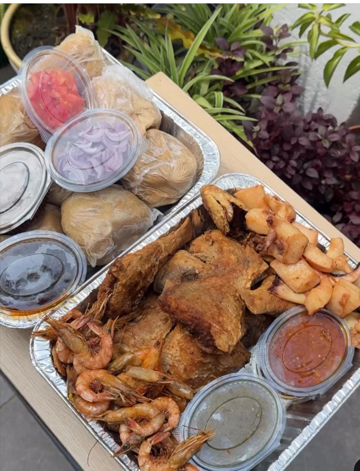 Ghanaian kenkey platter served with fish, shrimp, onions and pepper sauces