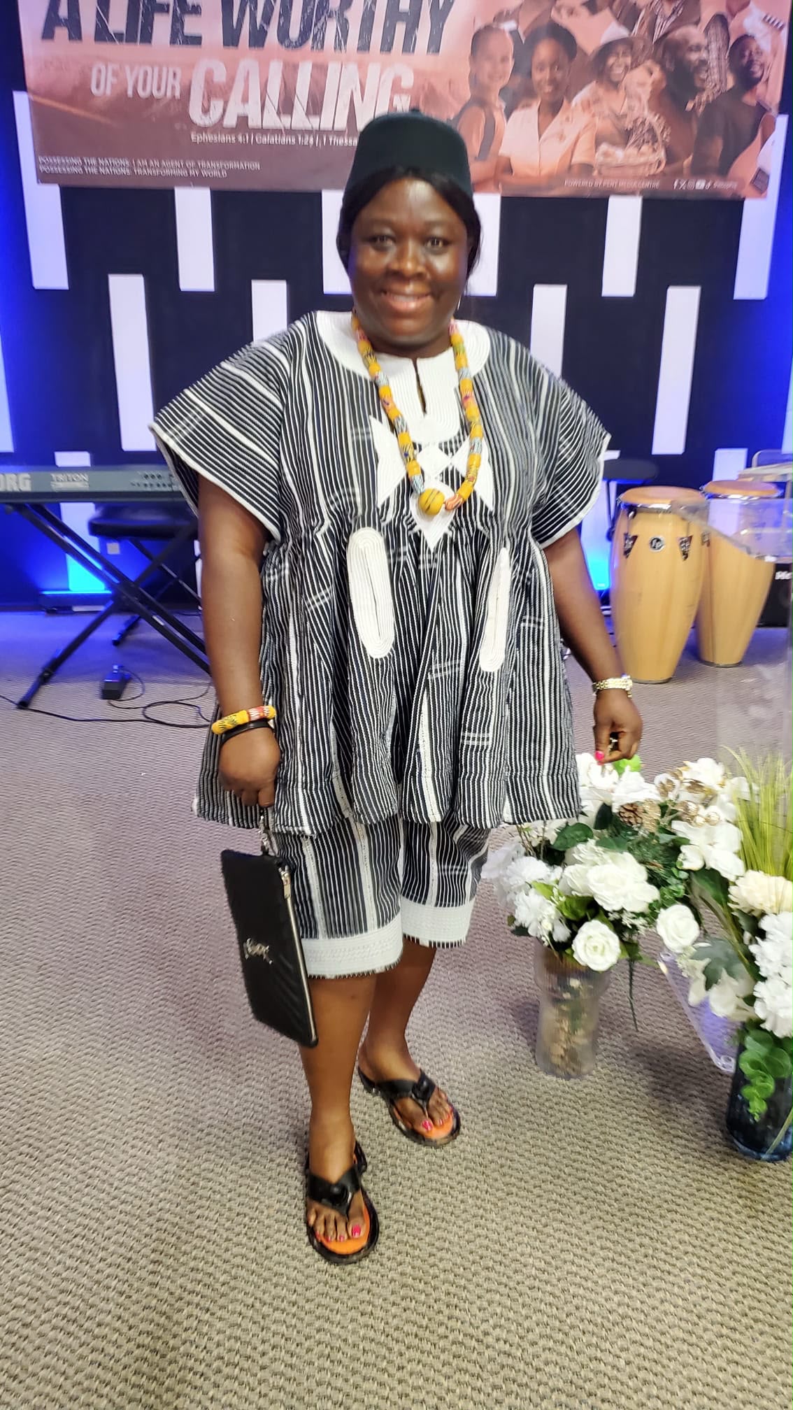 A woman wearing a traditional black-and-white Ghanaian smock at a cultural event